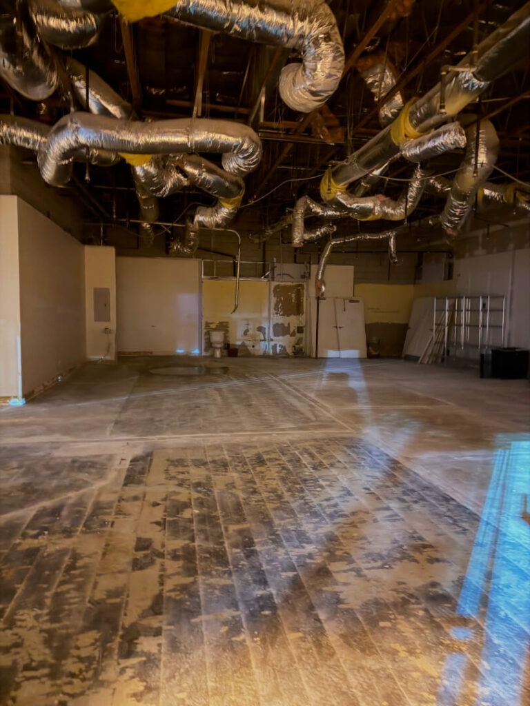 Empty interior space with exposed ductwork and unfinished floors.