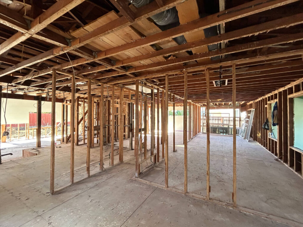 Spacious empty retail space with slat walls, a clean floor, and a counter in the background.
