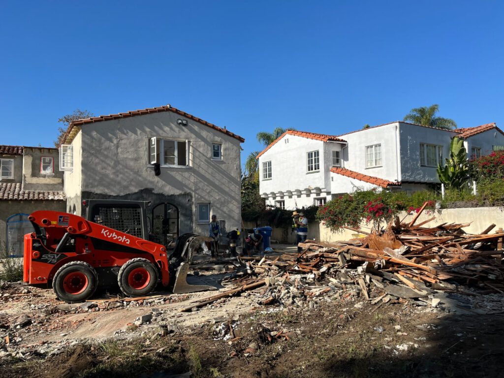 Exposed interior of a home renovation, showcasing framed walls and unfinished flooring.