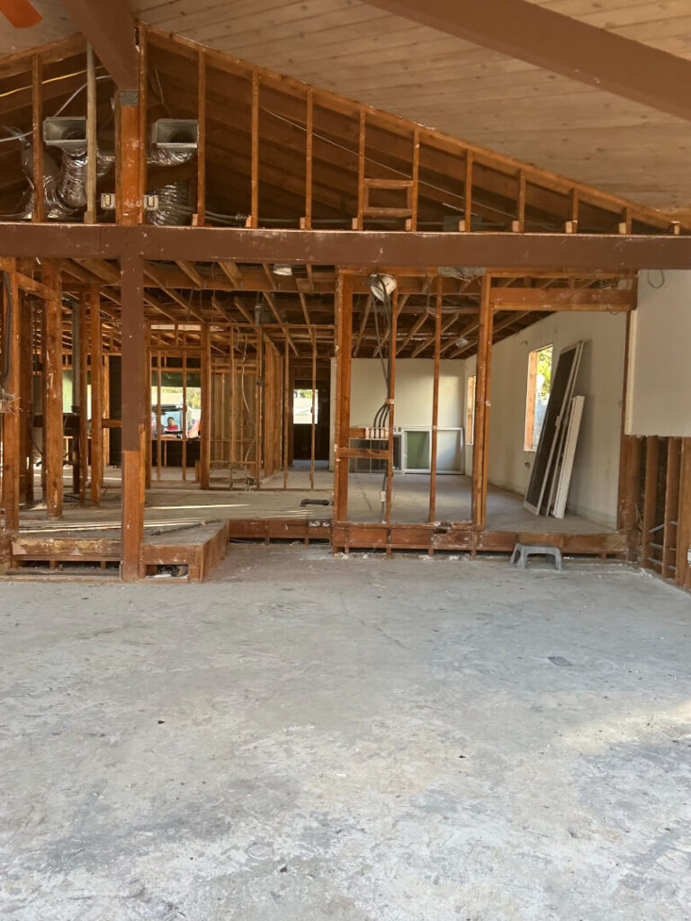 Open interior of a partially constructed home, showcasing exposed wooden framing.